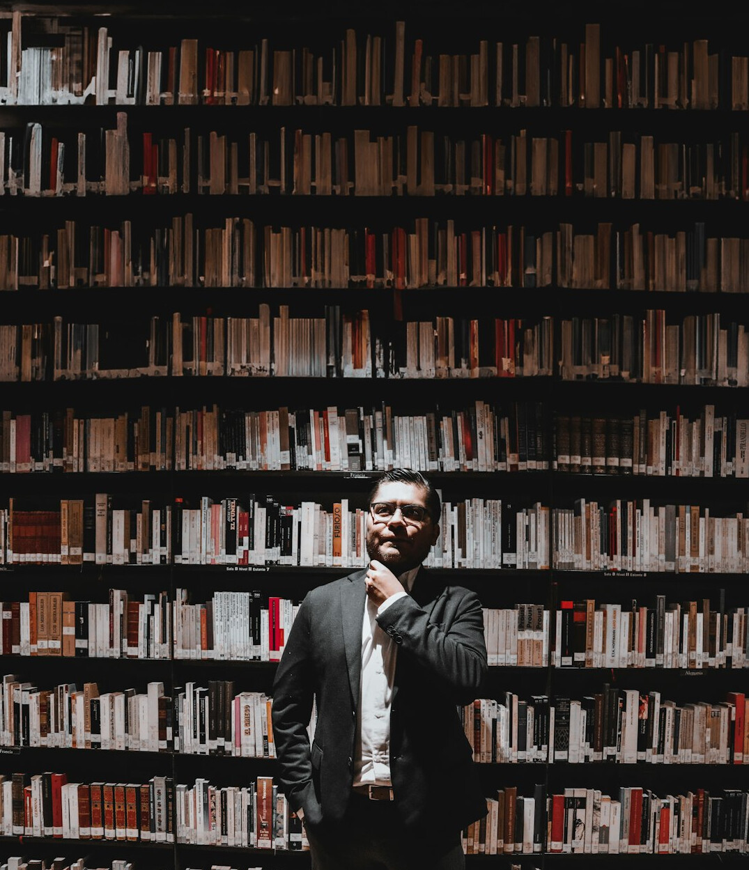 Portrait of a male researcher with glasses in a library